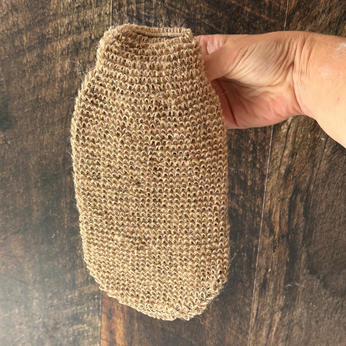 Gant de jute exfolliant entièrement naturel tenu par une main