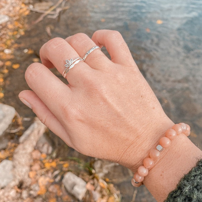 Bague Lotus en Argent Sterling 925 portée sur le majeur en combinaison avec les bagues Onde et Sunny, mettant en valeur la fleur de lotus en relief et les zircons, pour un look harmonieux et sophistiqué.