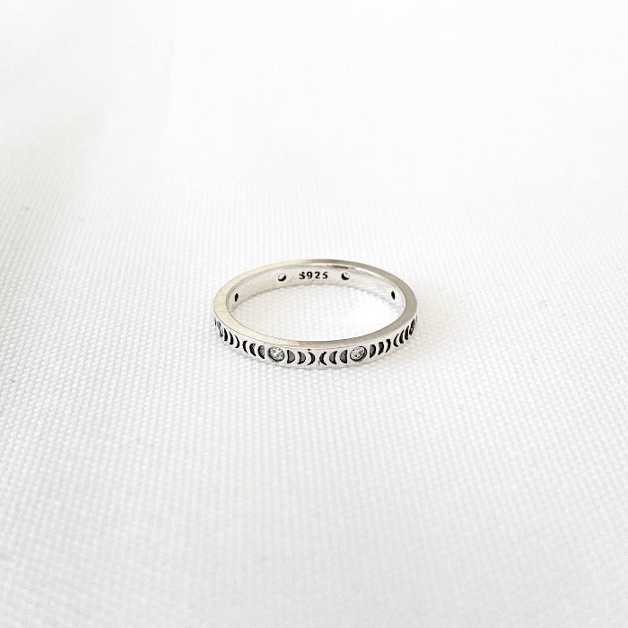 Vue de haut de la Bague Moonphase en Argent Sterling 925 sur fond blanc, mettant en évidence les phases lunaires en relief, un zircon à chaque pleine lune et le poinçon 925, garantissant la qualité de l'argent sterling.
