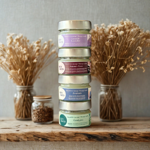 Quatre chandelles à massage Eco Loco à l’eucalyptus, lavande, zenitude, amour, soin nourrissant et hydratant, posée devant un bouquet de fleurs séchées sur un comptoir de bois.