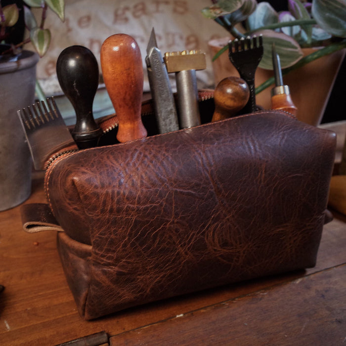 Premium chestnut leather grooming bag with spacious interior
