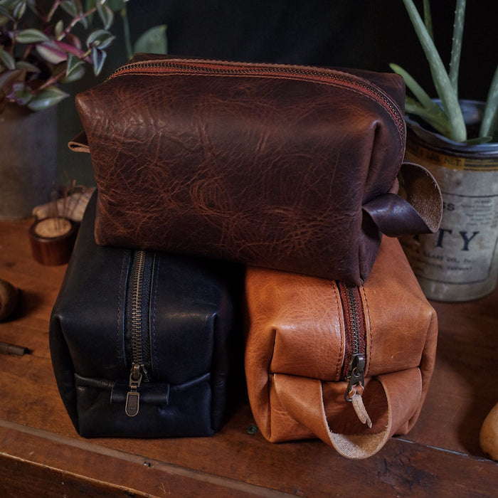 Stylish dark-brown leather toiletry bag with easy-access zipper
