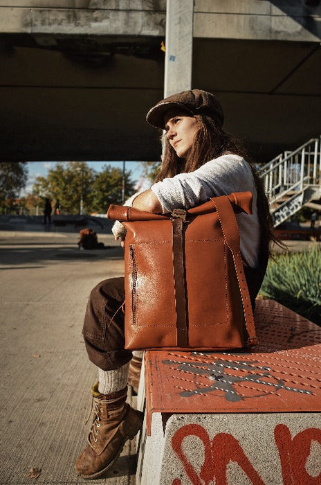 Durable light-brown leather roll-top backpack with adjustable shoulder straps
