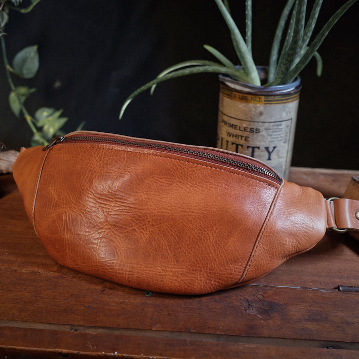 Spacious light brown leather moon bag with durable stitching
