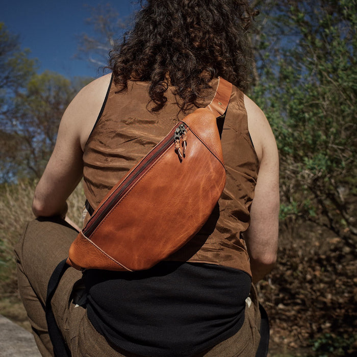 Durable caramel leather fanny pack with spacious compartments and zipper
