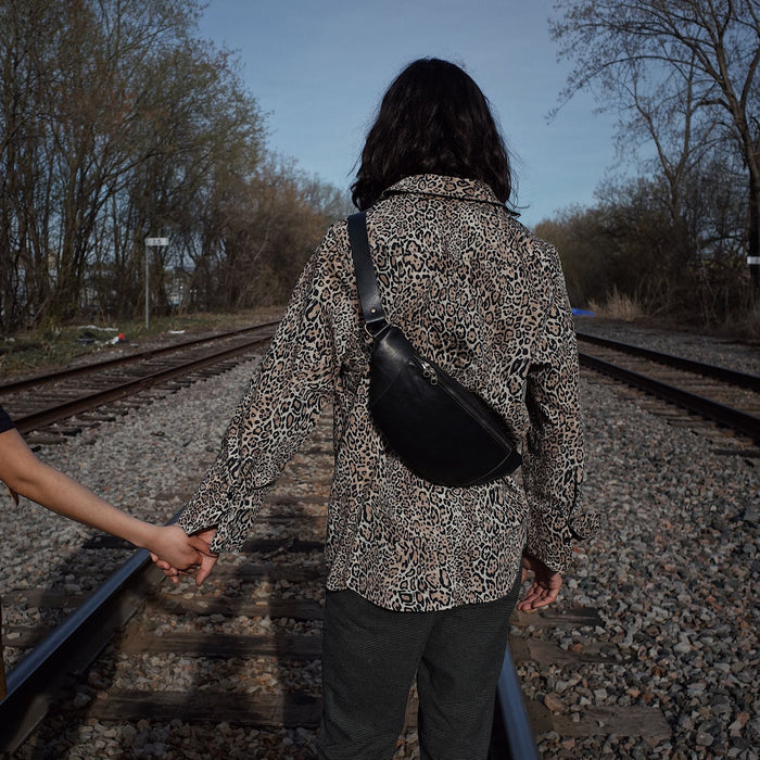 Roomy black leather waist bag with multiple storage pockets
