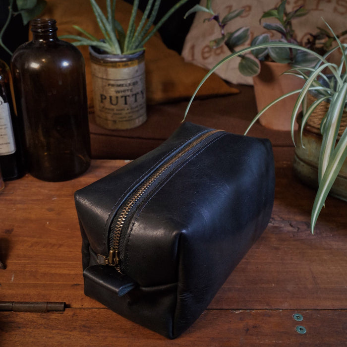 Minimalist black leather dopp kit for men and women, perfect for travel

