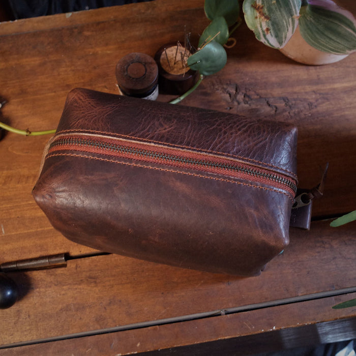Stylish chestnut leather dopp kit with reinforced zipper closure
