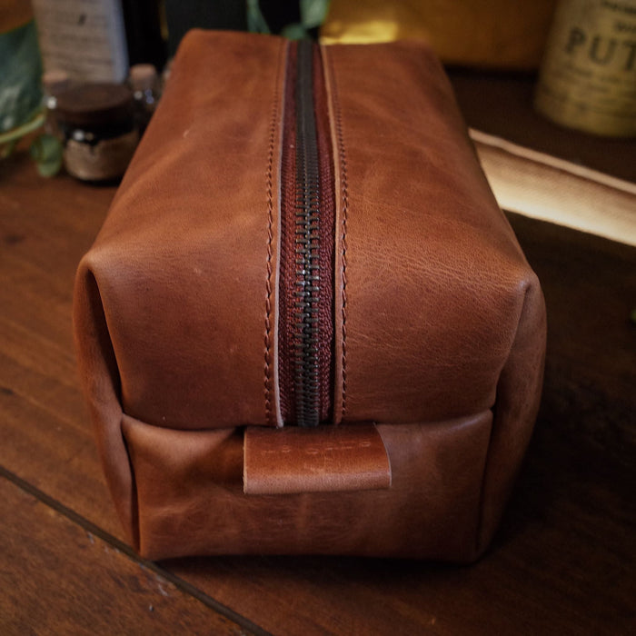 Sleek saddle tan leather dopp kit designed for convenient packing
