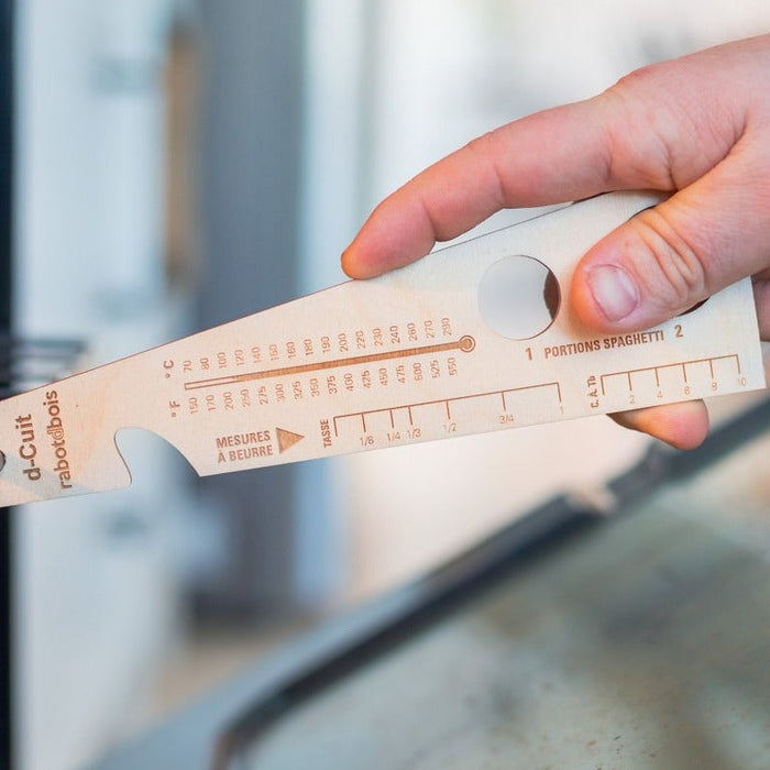 Un "Tire-pousse" pour la grille du four (voir images).  Mesures pour portions de spaghettis. Tables de conversions. Mesure à beurre.  Aimant à l'arrière pour le garder à portée de main !  Possibilité de faire fabriquer en mode corporatif.  Merisier russe 1/8" d'épaisseur.