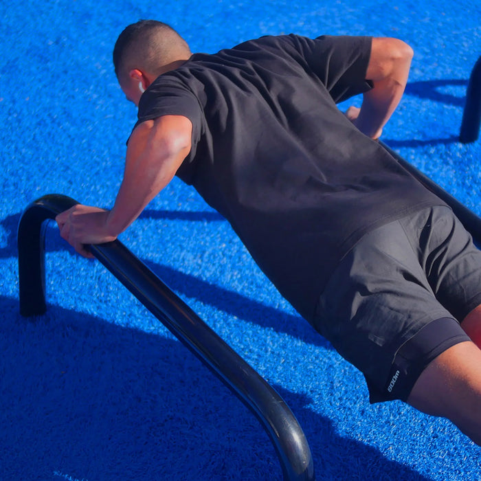 A man is training at an outdoor gym. He's wearing the 800m legband.
