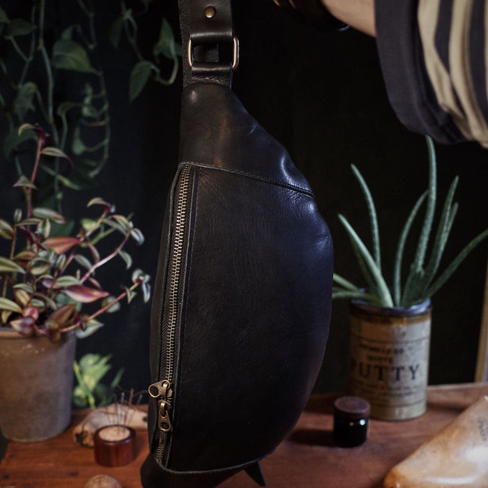 Large black leather fanny pack designed for roomy storage
