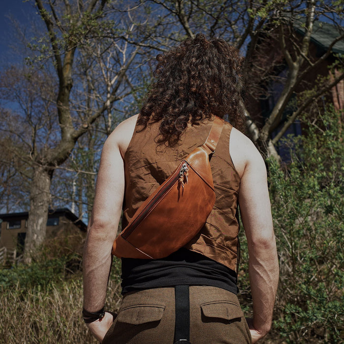 Large caramel leather waist bag designed for roomy storage
