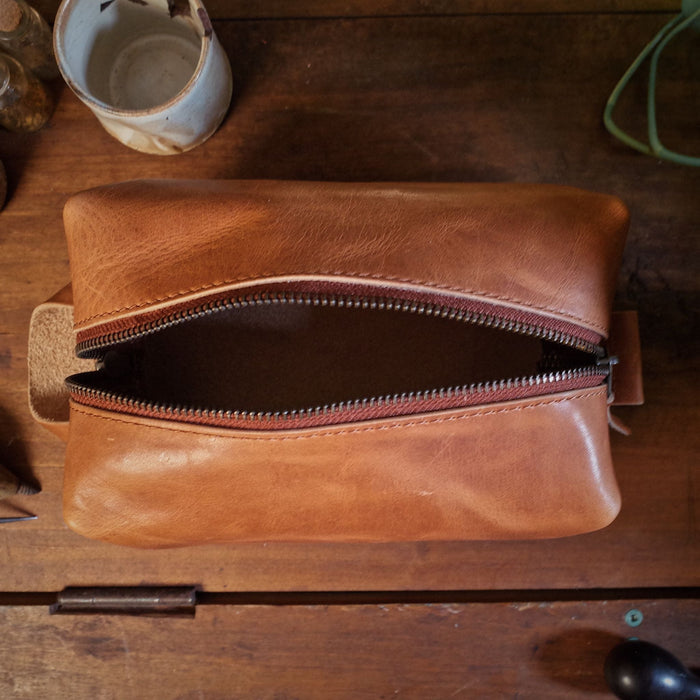 Compact honey brown leather accessory pouch for travel
