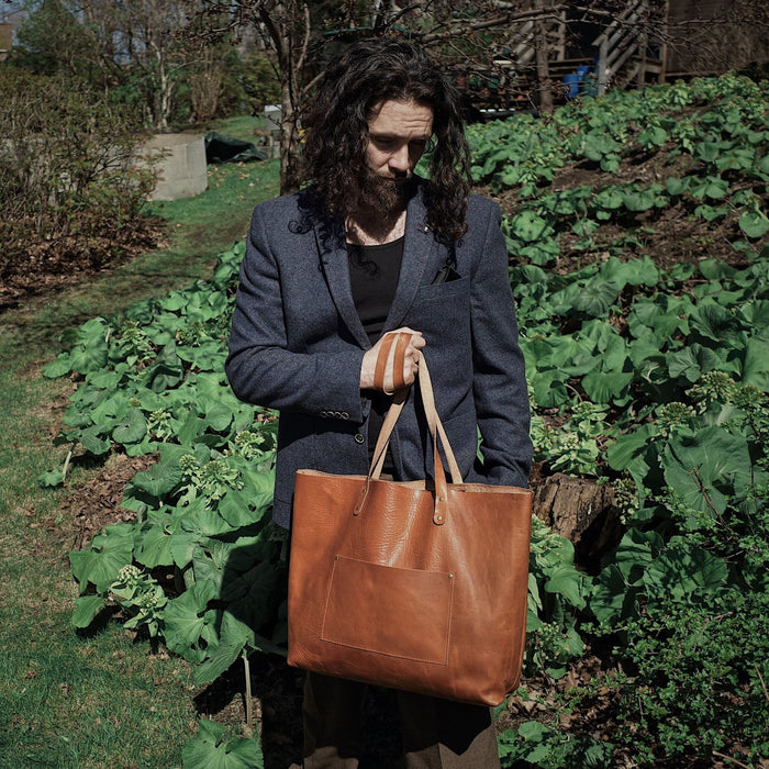 Light brown leather satchel with spacious compartments for travel essentials
