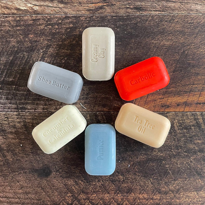 Savons écologiques rouges, blanc et bleu sur un fond de bois foncé