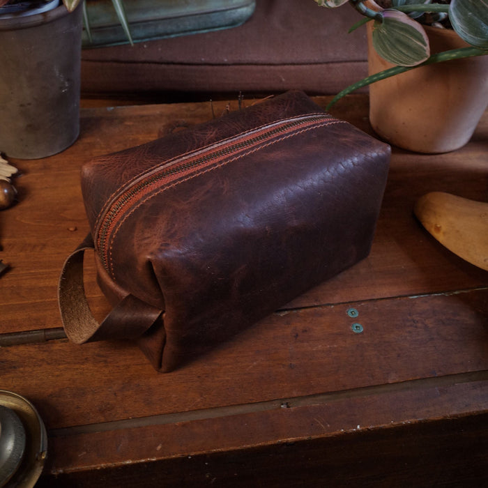 Full-grain chestnut leather grooming bag with minimalist design
