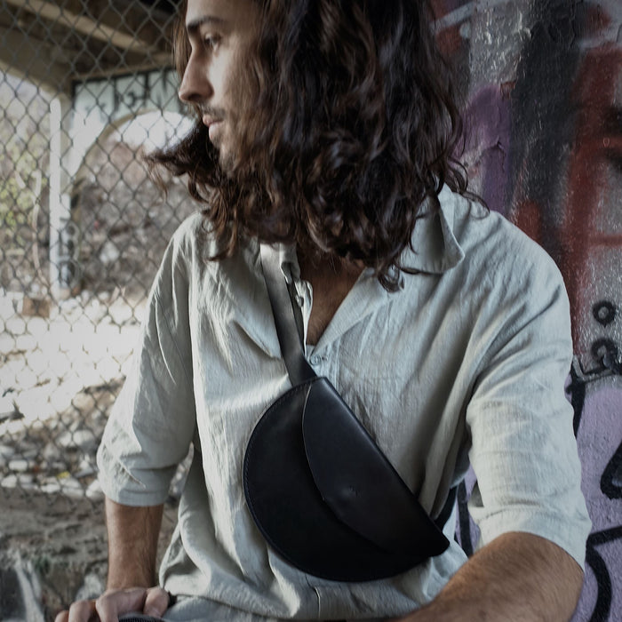 Artisanal black leather moon bag with a sleek, minimalist design
