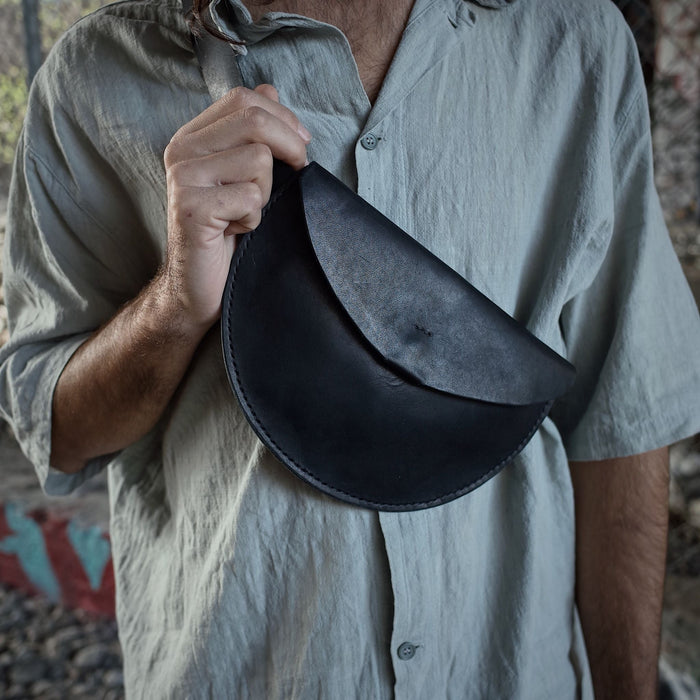 Full-grain black leather moon bag crafted for light carrying
