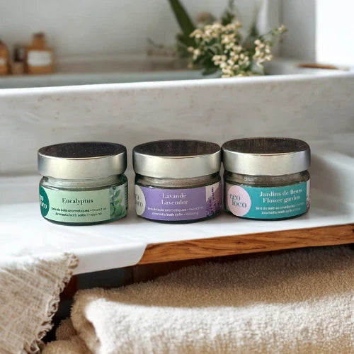 trois pots de sels de bains sur une tablette de bois dans une salle de bains lumineuse