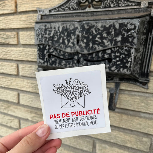 Une main qui tien un autocollant Pas de publicité idéalement juste des chèques ou des lettres d'amour, merci devant une boite à lettres.